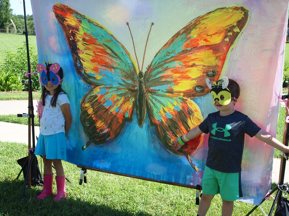 children in insect masks infront of a butterfly banner