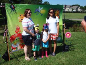 parents and children getting picture taken infront of a bee and butterfly sign